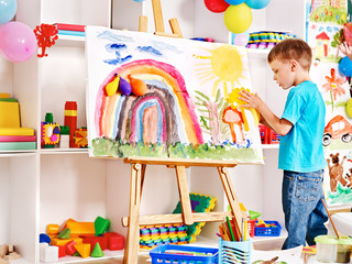 Child painting at easel.