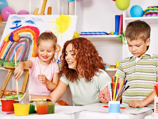 Child painting at easel.