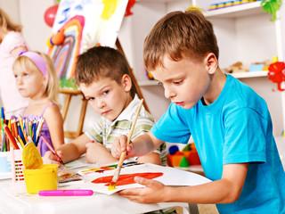 Children painting at easel.