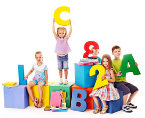 Children sitting at cube.