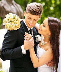 Groom embrace bride .