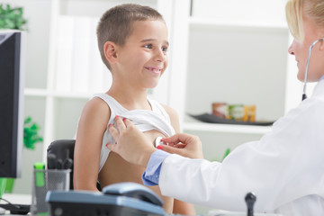 Fototapeta premium female doctor examining happy child, smiling.