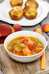 Bowl of tomato and pepper soup on wooden table. Autumn setting.