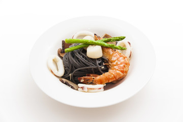 Black spaghetti with seafood on white background (squid ink past