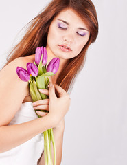 Beautiful girl with bunch of spring flowers