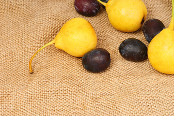 Some  pears and plums on burlap background