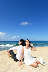 Fototapeta na wymiar 沖縄の美しいビーチで寛ぐカップル