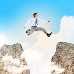 Businessman jumping over gap