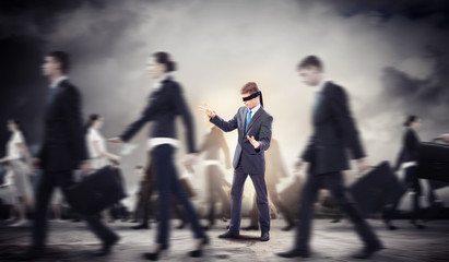 Businessman in blindfold among group of people