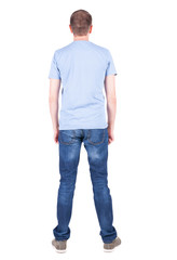 Back view of young man in t-shirt and jeans  looking.