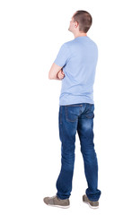 Back view of young man in t-shirt and jeans  looking.