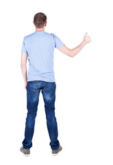 Fototapeta premium Back view of man in t-shirt. shows thumbs up.