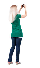 Back view of woman photographing. girl photographer in jeans. Re