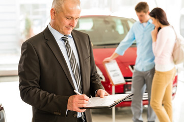 Caucasian salesman in car showroom