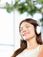 Woman enjoying music in headphones at home relaxed