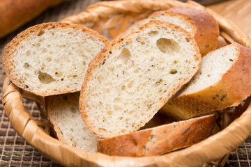pieces of baguette with herbs in a basket, close-up