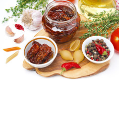 sun dried tomatoes, pasta and spices on wooden board, isolated