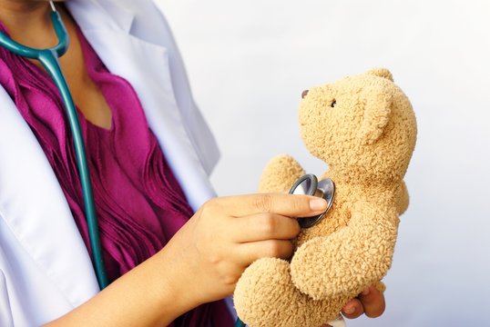 Nurse, using a stethoscope with doll