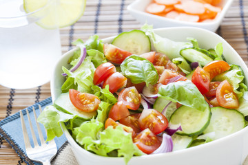 fresh green salad with lettuce, cucumber, tomato and red onion.
