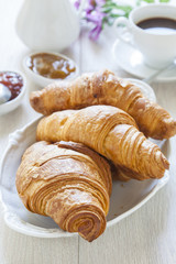 Croissants on table with jam and coffee