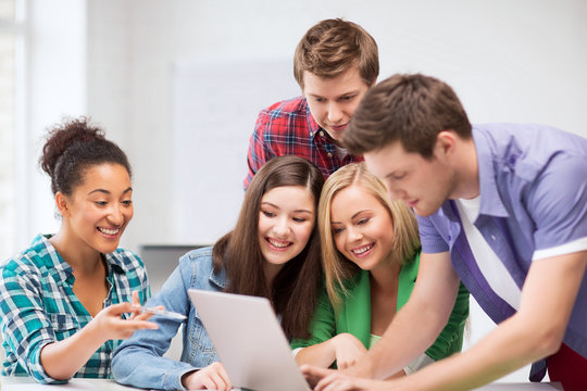 international students looking at laptop at school