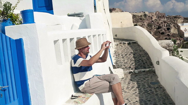Tourist taking photo with cellphone on Santorini