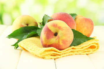 Ripe sweet peaches on wooden table in garden, close up