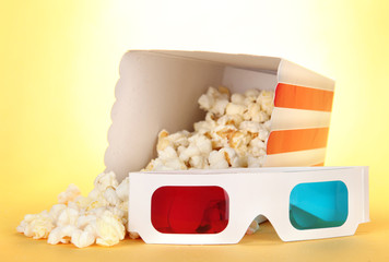 Popcorn and 3D glasses on yellow background © Africa Studio
