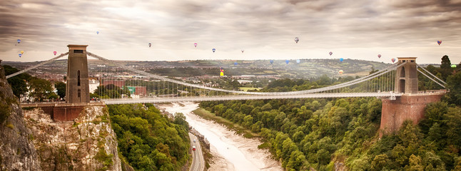 Hot air balloons behind suspension bridge - obrazy, fototapety, plakaty