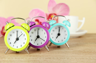 Colorful alarm clock on table on beige background