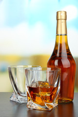 Glass of whiskey with bottle, on dark background