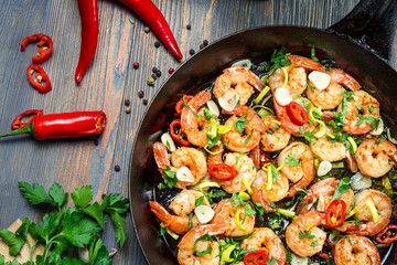 Shrimps fried on pan with fresh herbs