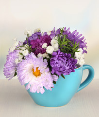 Beautiful bouquet of bright flowers in color mug,