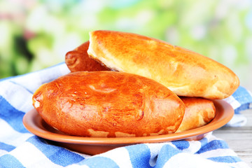 Fresh baked pasties, on wooden table, on bright background