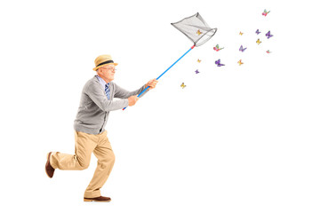 Mature man running and catching butterlies with net