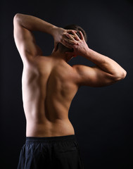 Fototapeta na wymiar Handsome young muscular sportsman, on dark background