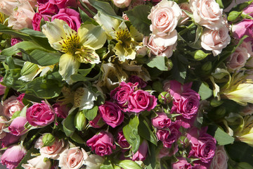 bouquet of yellow, pink, red and cream roses in  bride hands.