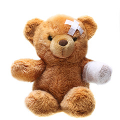 Classic teddy bear with bandages isolated on white background
