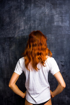 Redhead woman by blank blackboard