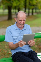 Friendly handsome old man with tablet computer