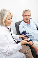 Ärztin misst Blutdruck bei Senioren