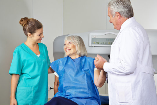 Arzt und MTA helfen Seniorin in Radiologie