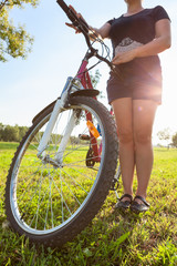 Fototapeta na wymiar Woman cyclist with bike in the sunshine