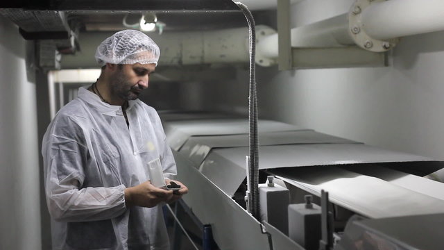 Worker controlling the quality of sugar in a factory