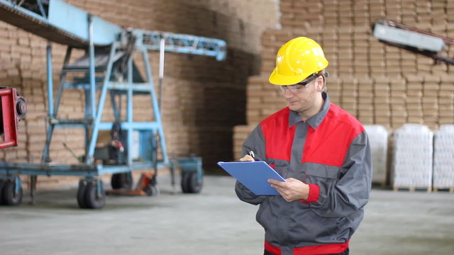 Worker writing on clipboard in Warehouse