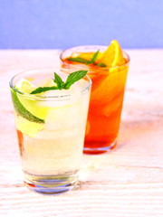 Elderflower, orange cocktails on blue background, close up