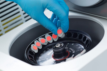 Scientist loading a sample to centrifuge