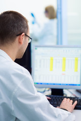 Scientist sitting in front of a computer analyzing data