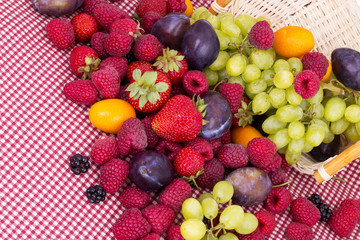 tasty summer fruits on a red tablecloth