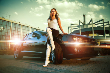 beautiful woman stands in front of sport car